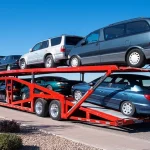 Car Hauler Transporting Multiple Vehicles on Red Trailer on Roadway